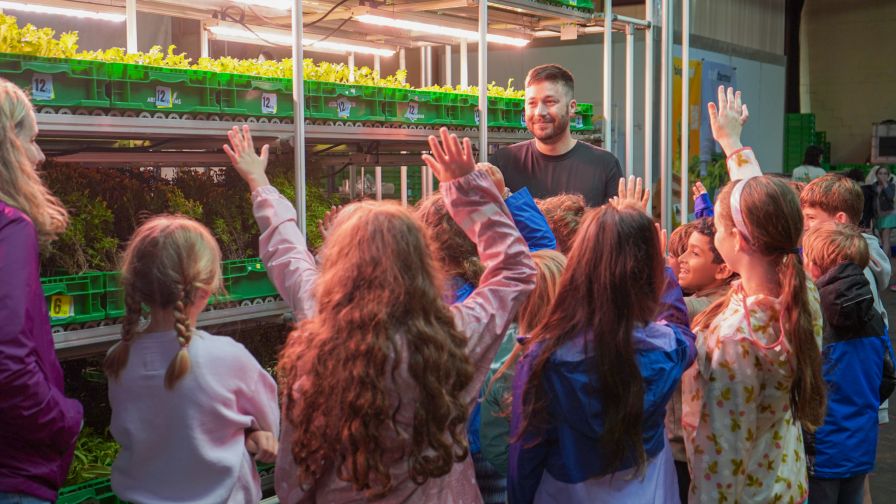 Tyler Baras, co-founder and chief science officer of Area 2 Farms, leads a school tour at the company’s Arlington, Va., location.